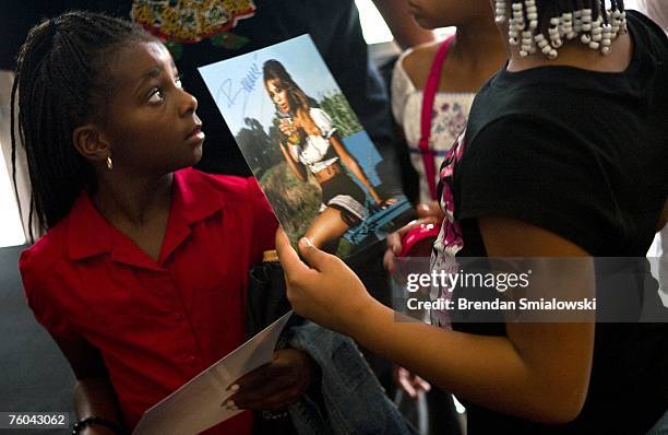 Fan waits after donating canned goods in exchange for an autographed photo of singer Beyonce and a raffle ticket before a Beyonce concert August 9,...