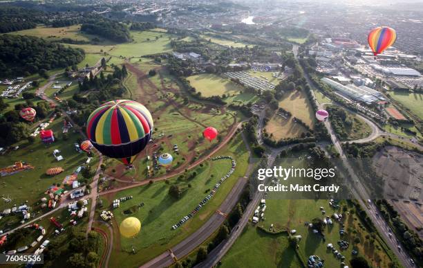 Balloons participating in the mass early morning ascent start to rise in to the skies above Ashton Court at the Discovery Channel International...