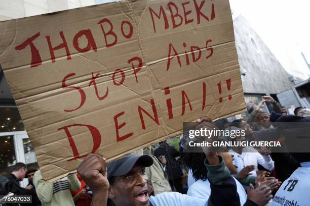 Activist holds a banner, 10 August 2007, as his comrades sing and dance after South African axed Health deputy minister Nozizwe Madlala-Routledge...