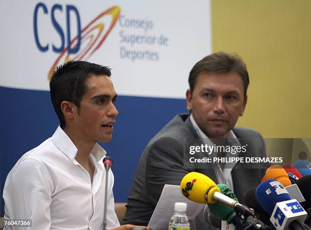 Spanish cyclist and winner of Tour de France 2007 Alberto Contador reads a statement as Johan Bruyneel, Sport director of the Discovery Channel Team...