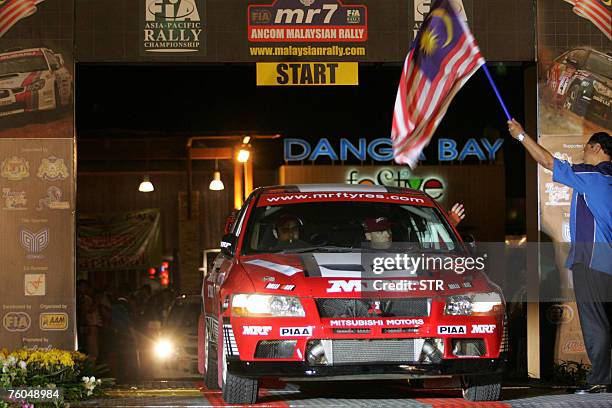 Indian driver Gaurav Gill and co-driver Australian Karl Francis of MRF Tyres Rally Team drive their Mitsubishi Lancer Evo 7 past the gates during the...