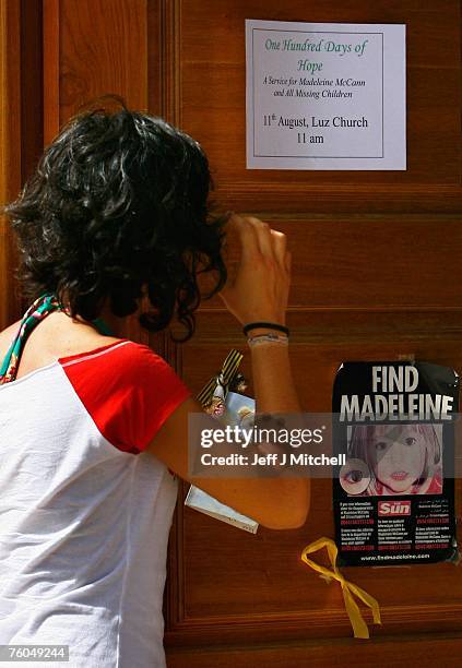 Woman looks at a poster and cards placed on the Church door in Praia da Luz for missing Madeleine McCann August 10, 2007 in Praia da Luz, Portugal....