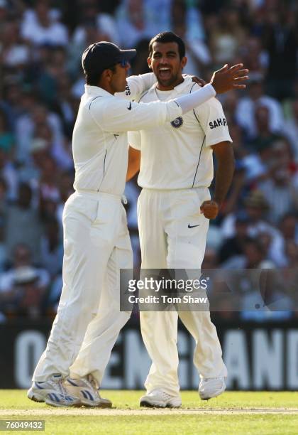 Zaheer Khan of India celebrates the wicket of Andrew Strauss of England with captain Rahul Dravid during day two of the Third Test match between...