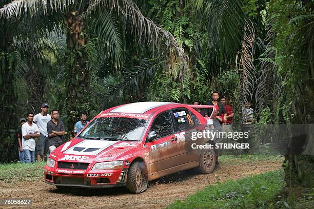 Indian driver Gaurav Gill and co-driver Australian Karl Francis of MRF Tyres Rally Team drive through with a punctured tyre on their Mitsubishi...