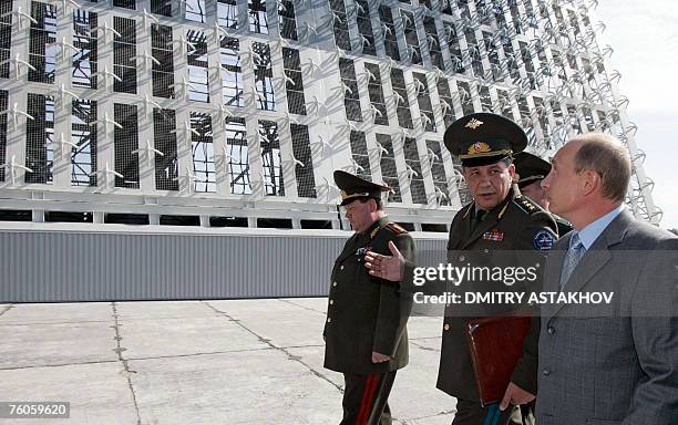 Russian President Vladimir Putin listens to Colonel General Vladimir Popovkin , commander-in-chief of the space forces, during his visit to a...