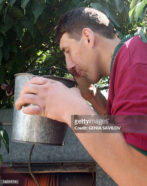 Leonid Stadnyk tastes draw-well water from a 10-litre bucket at his house in Podoliantsi village, 180 km from Kiev, 11 August 2007. Leonid Stadnyk, a...