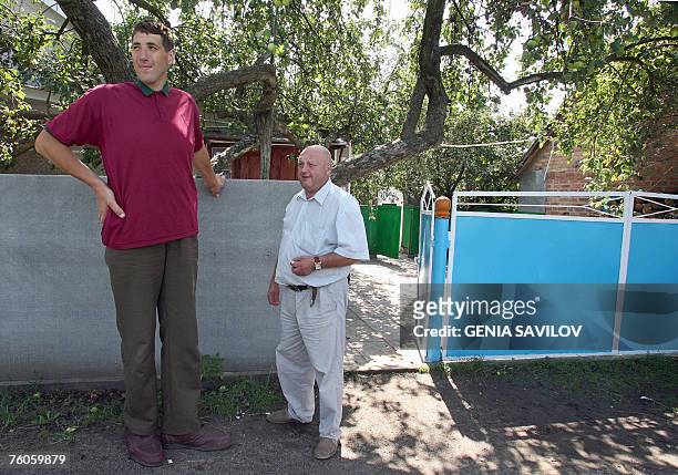 Leonid Stadnyk stands beside a man outside his house in Podoliantsi village, 180 km from Kiev, 11 August 2007. Leonid Stadnyk, a giant veterinary...