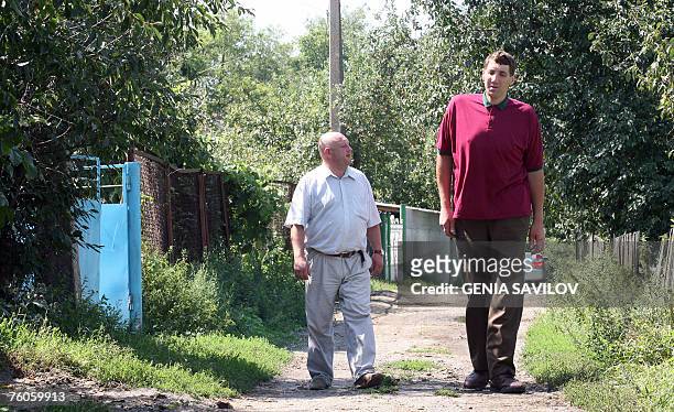 Leonid Stadnyk walks beside a man in Podoliantsi village, 180 km from Kiev, 11 August 2007. Leonid Stadnyk, a giant veterinary surgeon from northwest...