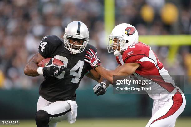 Wide receiver Jerry Porter of the Oakland Raiders is tackled by defensive back Terrence Holt of the Arizona Cardinals on August 11, 2007 at McAfee...