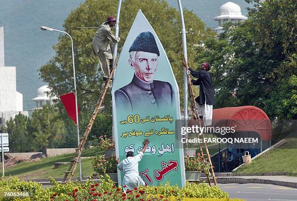 Pakistani workers install a banner featuring the founder of Pakistan, Mohammad Ali Jinnah on a street in Islamabad, 12 August 2007, in preparation...