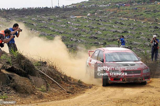 Indian driver Gaurav Gill and co-driver Australian Karl Francis of MRF Tyres Rally Team take a corner with a punctured tyre on their Mitsubishi...