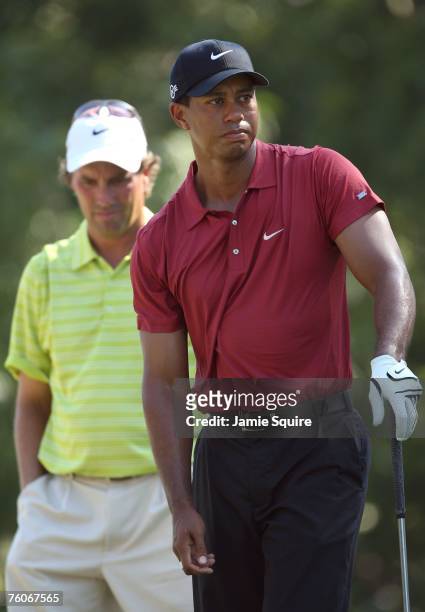Tiger Woods watches a tee shot as Stephen Ames of Canada looks on during the final round of the 89th PGA Championship at the Southern Hills Country...