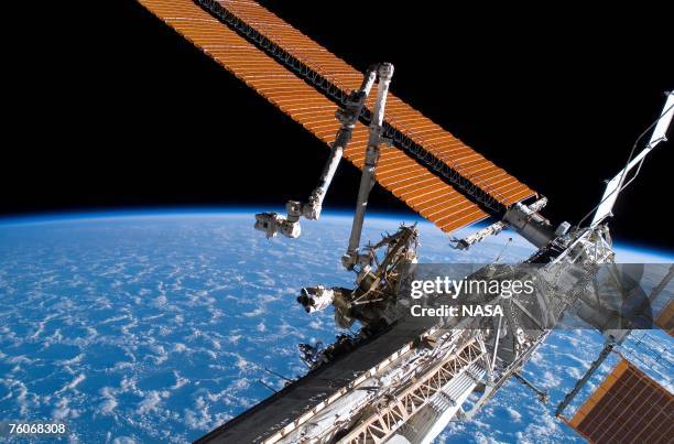 In this handout photo provided by NASA, the Canadarm2 and solar array panel wings on the International Space Station are extended during the...