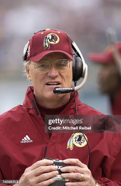 Coach Marty Schottenheimer of the Washington Redskins wearing his Adidas jacket as he watches the game action against the Baltimore Ravens. The...