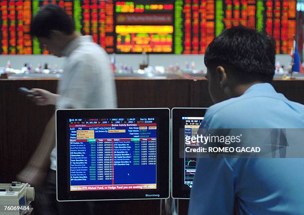 Traders check prices on a computer screen at the Philippine Stock Exchange in Makati, suburban Manila, 13 August 2007. Share prices closed 0.40...