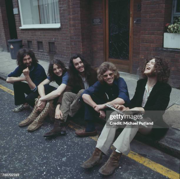 British rock group Supertramp posed together sitting on the pavement outside the Revolution Club, London, August 1970. Left to right: Rick Davies,...