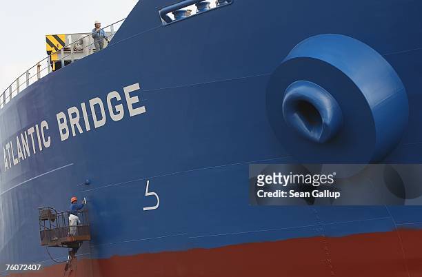 Worker paints the hull of a ship at the Blohm & Voss shipyard August 13, 2007 in Hamburg, Germany. Northern Germany, with its busy ports of Hamburg,...