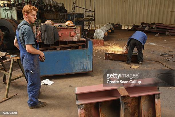 Worker stands by while a welder welds a part of a ship at the Blohm & Voss shipyard August 13, 2007 in Hamburg, Germany. Northern Germany, with its...