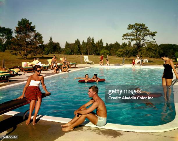 People swim in the outdoor swimming pool at the Tocker Mill Inn, Southampton, New York, 1960s.