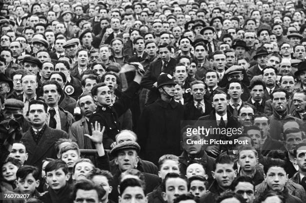 Police officers in the crowd at Ibrox during an Rangers vs Celtic Old Firm match, 15th October 1949. Original Publication : Picture Post - 4894 -...