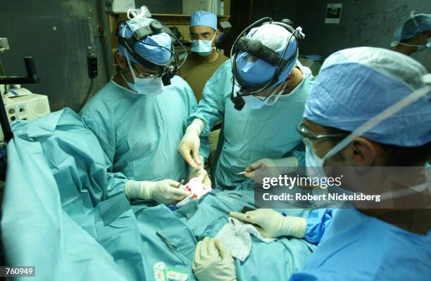 Army medical surgeons Major Dr. Tad Gerlinger of Saliene, MI, Lt. Col Dr. George Peoples of Everton, MD and Sgt. John Dominguez, a scrub tech from...