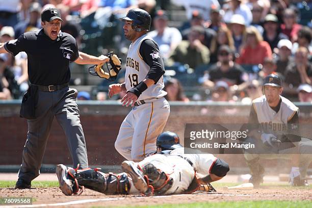 Guillermo Rodriguez of the San Francisco Giants makes a late tag at home plate as Pittsburgh Pirates base runner Jose Bautista is called safe by home...