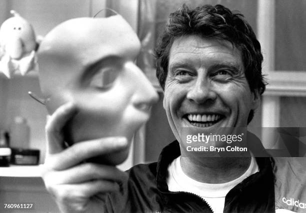 In his dressing room, British actor Michael Crawford, star of Andrew Lloyd Webber's musical, 'Phantom of the Opera', holds the phantom mask during a...