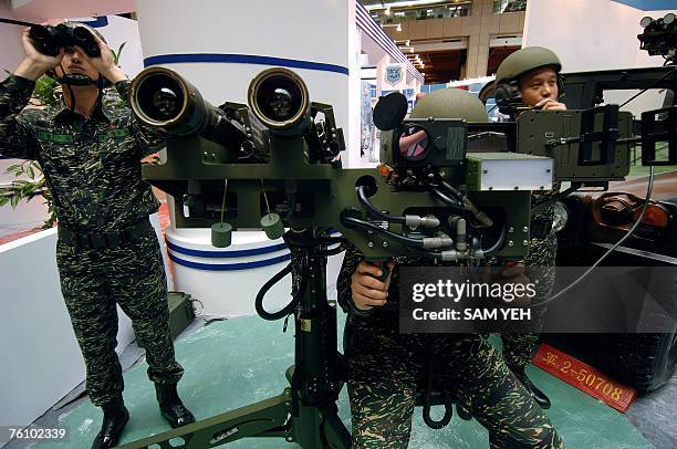 Three Taiwanese soldiers demonstrate a US-made dual mounted stinger missiles during the aerospace and defense technology exhibition at the World...
