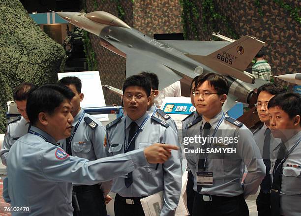 Taiwanese airforce officers listen to instructions in front of a US-made F-16 figther model, during the aerospace and defense technology exhibition...