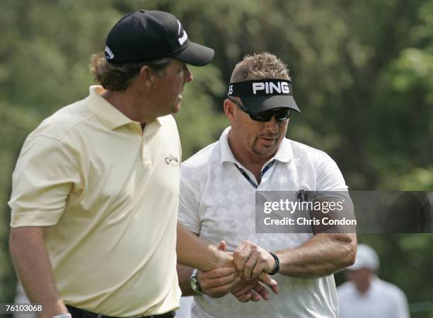 Phil Mickelson gets therapy on his left wrist from Jim Weathers before withdrawing on the 11th hole during the first round of the Memorial Tournament...