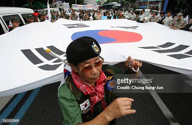South Korean war veterans and anti-North Korea protesters hold a huge South Korean national flag during a rally opposing the planned inter-Korean...