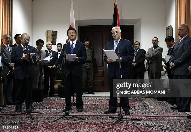 Japan's Foreign Minister Taro Aso and Palestinian president Mahmud Abbas give a joint press conference following their meeting at his offices in the...