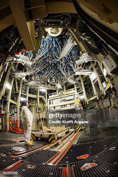 An Employee looks up at the control rods unit for fuel elements while the reactor is turned off for a routine inspection at the nuclear power plant...