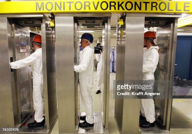 Employees pass through a pre-control monitor station to detect possible radioactive contamination, during a routine inspection at the nuclear power...