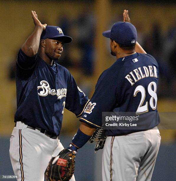 Bill Hall of the Milwaukee Brewers, left, exchanges high-fives with Prince Fielder in celebration after 8-5 victory over the Los Angeles Dodgers in...