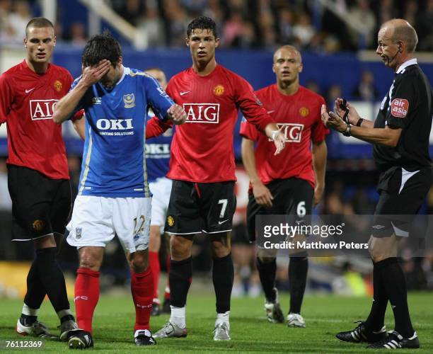Cristiano Ronaldo of Manchester United looks surprised at the reaction of Richard Hughes of Portsmouth after a clash for which Ronaldo was sent off...