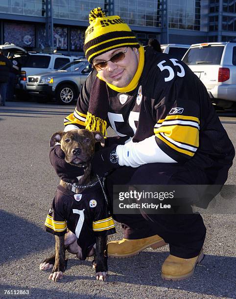 Pittsburgh Steelers fan David Martinsky, wearing No. 55 Joey Porter jersey, poses with seven-month old Pit Bull "Tiny," wearing No. 7 Ben...