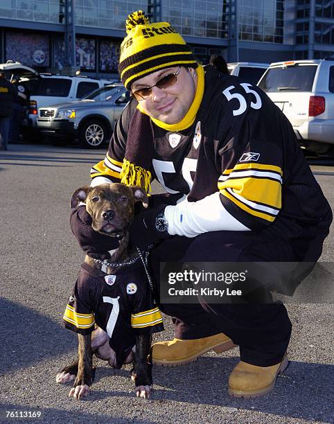 Pittsburgh Steelers fan David Martinsky, wearing No. 55 Joey Porter jersey, poses with seven-month old Pit Bull "Tiny," wearing No. 7 Ben...