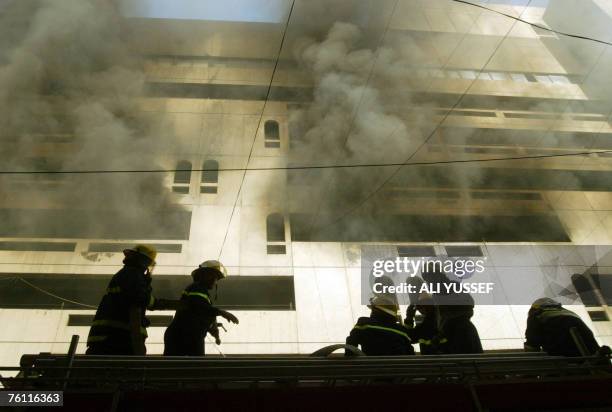 Iraqi firemen douse the flames at the site where a car bomb exploded in a popular shopping complex, in central Baghdad, 16 August 2007. The blast,...