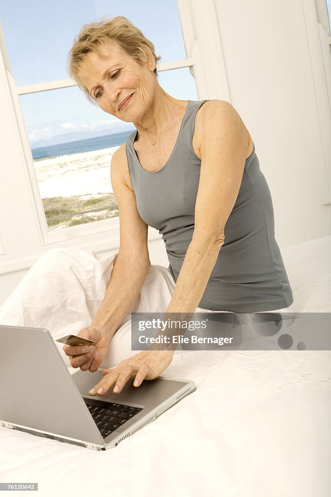 Senior woman using credit card on internet