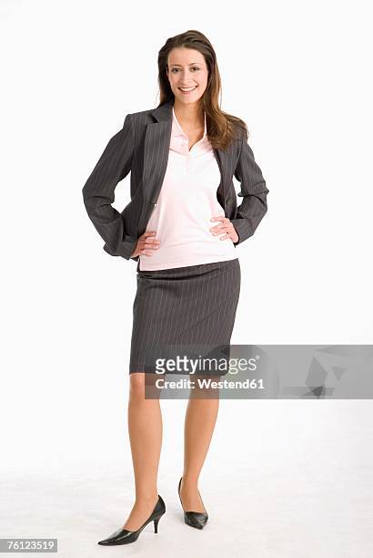 businesswoman standing with hands on hip, smiling, portrait - falda blanca fotografías e imágenes de stock