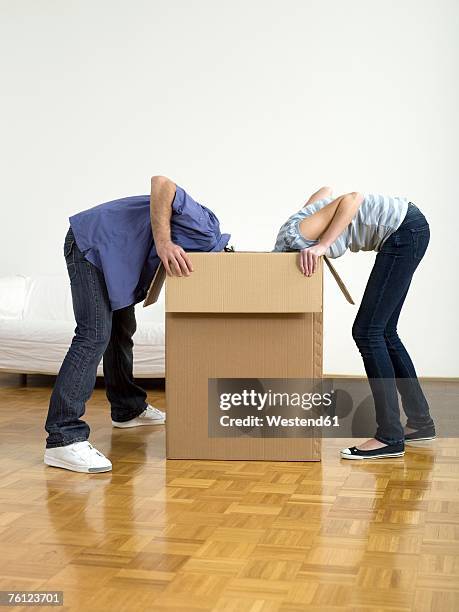 couple looking in box - leaning over stock pictures, royalty-free photos & images