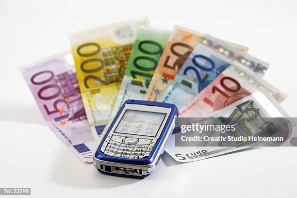 mobile phone on bank notes, close-up - two hundred euro banknote stock pictures, royalty-free photos & images