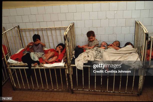 Children lay in a bed in an orphanage May 14, 1990 in Vulturesti, Romania. The orphanage is for children who have birth defects such as retardedness...