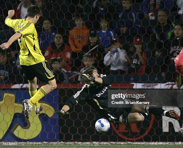 Columbus Crew forward Jason Garey, left, fires a shot past Chicago Fire goalkeeper Matt Pickens for a goal during the first half at Toyota Park in...