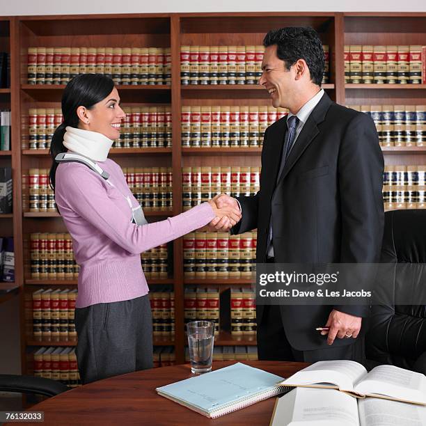 male lawyer shaking hands with injured client - personal injury claim stock pictures, royalty-free photos & images