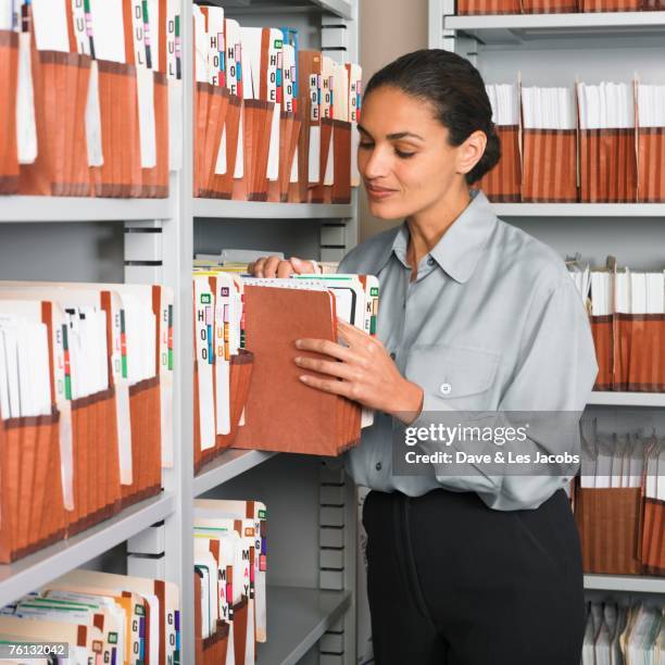 hispanic businesswoman in file room - will files stock pictures, royalty-free photos & images