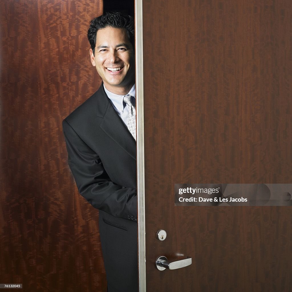 Mixed Race businessman walking through doorway