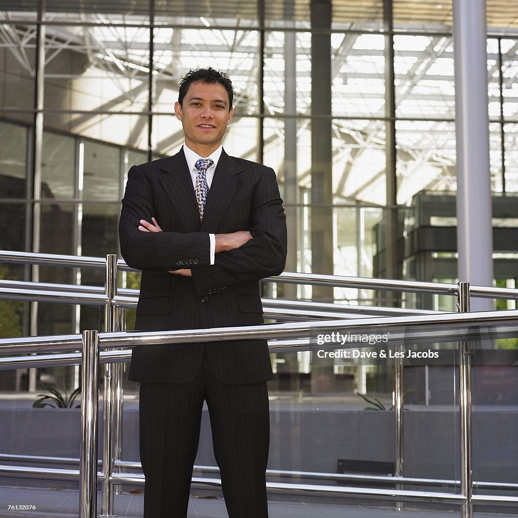 Mixed Race businessman with arms crossed