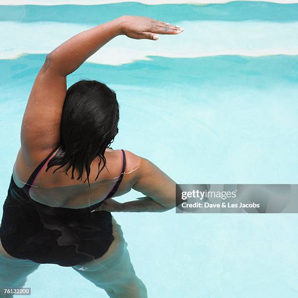 senior mixed race woman exercising in swimming pool - aquarobics stock-fotos und bilder